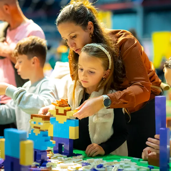 Een moeder en dochter bouwen samen aan een LEGO creatie