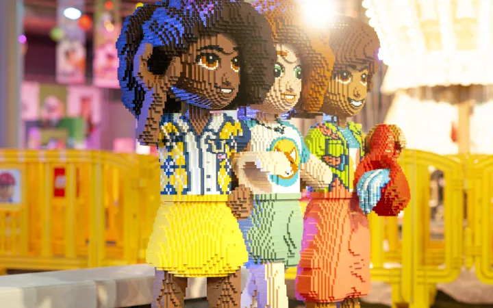 Drie levensgrote LEGO Friends-figuren staan naast elkaar.