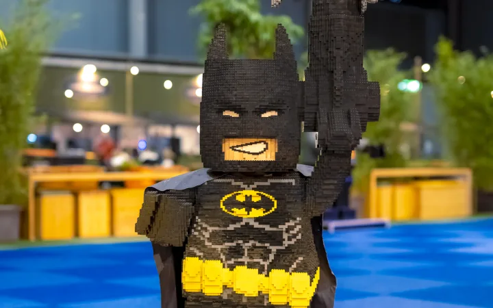 Een levensgroot standbeeld van LEGO Batman, met één arm geheven.
